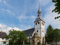 Außenansicht der Pfarrkirche St. Georg in Hopsten mit Kirchturm und umliegenden Fachwerkhäusern
