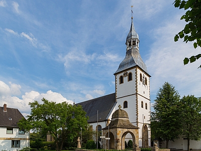 Außenansicht der Pfarrkirche St. Georg in Hopsten mit Kirchturm und umliegenden Fachwerkhäusern