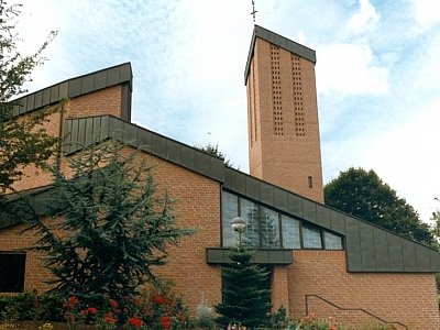 Außenansicht der Pfarrkirche St. Margaretha in Westerkappeln mit rotem Backsteinbau, großem Turm und Gartenanlage