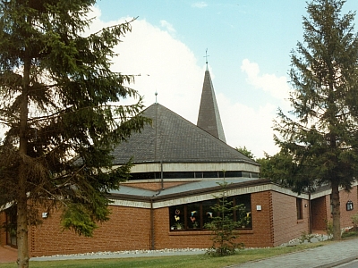 Außenansicht der Kirche St. Hedwig in Lotte mit modernem Schiff-artigen Baukörper und Turmaufsatz