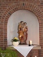 Madonnenstatue mit Jesuskind in der Pfarrkirche St. Mariä Himmelfahrt Schlickelde Madonna mit Jesuskind in einer Nische der Pfarrkirche St. Mariä Himmelfahrt in Schlickelde, mit Blume und Kerze