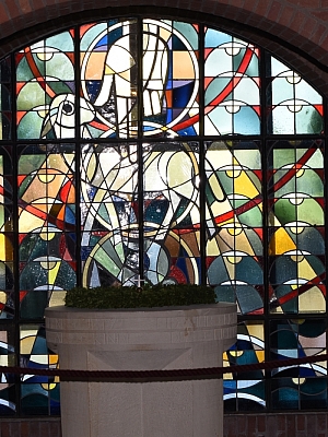 Buntglasfenster mit Taubendarstellung und Taufbecken in der Pfarrkirche St. Mariä Himmelfahrt Schlickelde