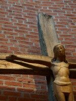 Holz-Kruzifix an Backsteinwand in der Pfarrkirche St. Margaretha in Westerkappeln Darstellung des gekreuzigten Christus als Holzskulptur vor Backsteinwand in der Pfarrkirche St. Margaretha in Westerkappeln