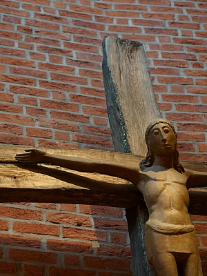 Darstellung des gekreuzigten Christus als Holzskulptur vor Backsteinwand in der Pfarrkirche St. Margaretha in Westerkappeln