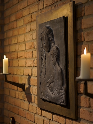 Reliefdarstellung von Maria mit dem Jesuskind, flankiert von zwei Kerzen in der Kirche St. Franziskus in Wersen